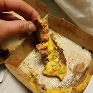 a person taking a piece of food out of a box