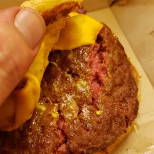 a hand holding a hamburger