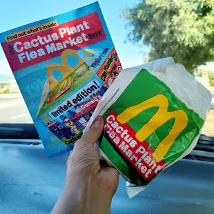 a hand holding a packet of fast food
