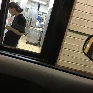 a woman in a kitchen through a window