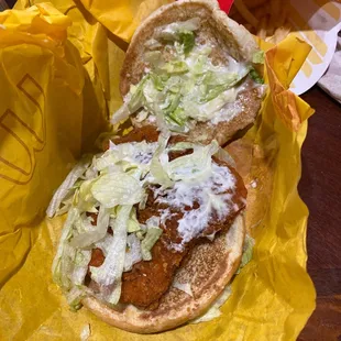 a chicken sandwich with lettuce and cheese