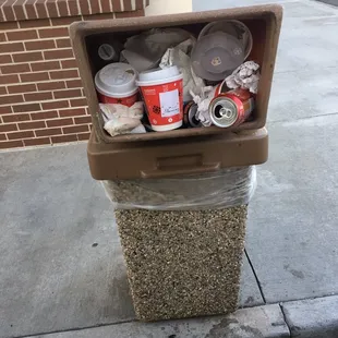 a trash can on the sidewalk