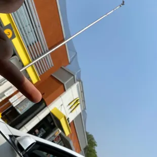 a hand pointing at a hot dog