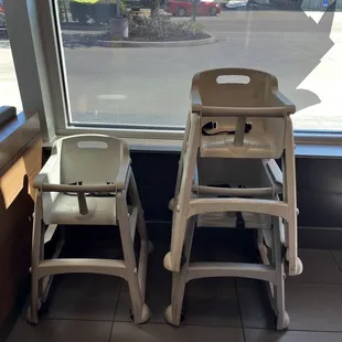 two high chairs in front of a window