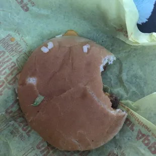 a half eaten hamburger in a wrapper