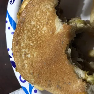 a half eaten sandwich on a paper plate