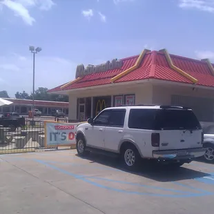 a white suv parked in front of a mcdonald&apos;s