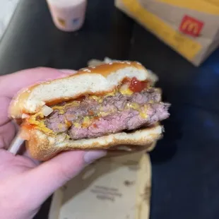 a hand holding a hamburger