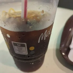 Fresh dispensed coke with 2 bubbles clinging on the side of the cup.