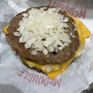 a hamburger covered in cheese and onions
