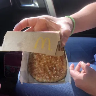 a person holding a box of pizza