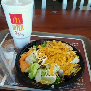 a salad and a drink on a tray