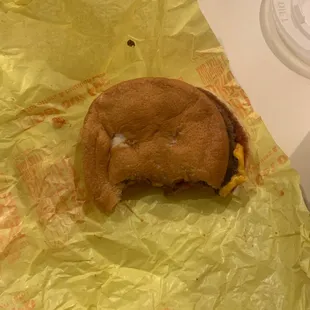 a half eaten sandwich and a cup of coffee