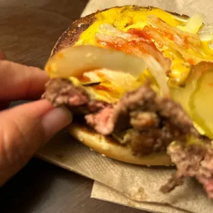 a hand holding a hamburger