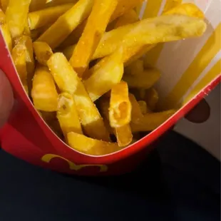 a person holding a basket of french fries