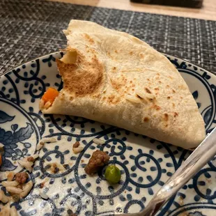 a half eaten burrito on a plate