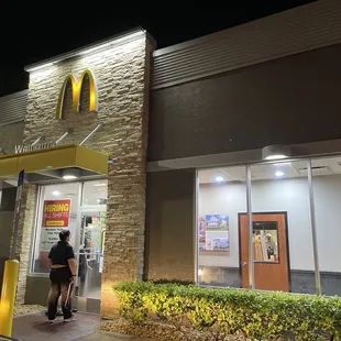 a man walking in front of a mcdonald's