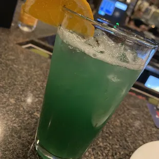 a green drink with a slice of orange