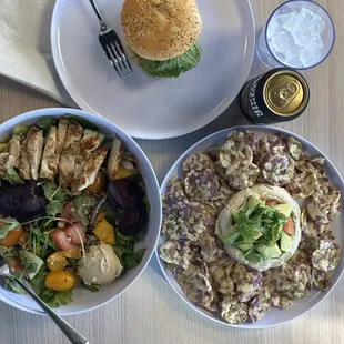 two bowls of salad and a burger