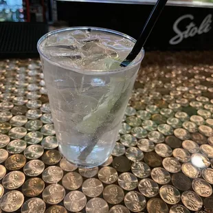 a glass of water with ice and a straw