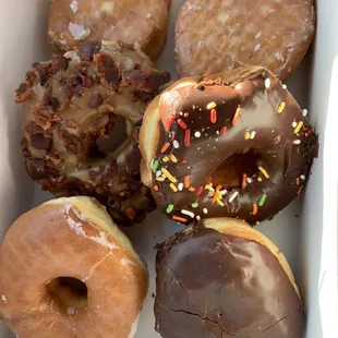 Top: Filled raspberry and lemon  Middle: Maple bacon and chocolate sprinkled  Bottom: Plain glazed and Boston cream