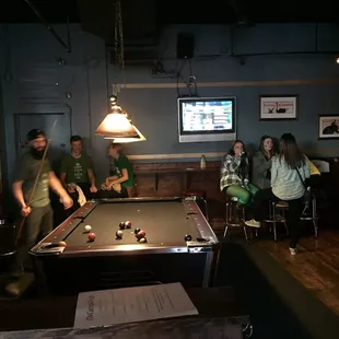 a group of people playing pool