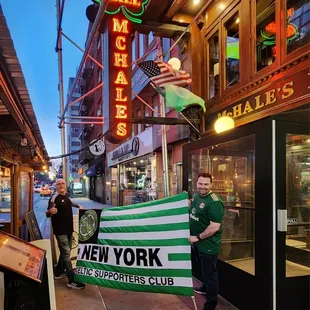 a man holding a green and white banner