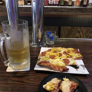 Pizza with pepperoni and banana peppers with a cold budlight to wash it down.
