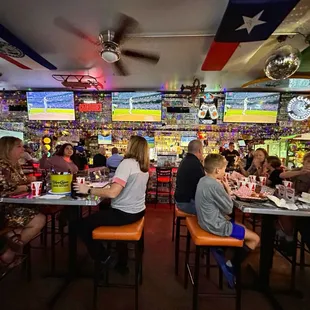 Tables and bar with baseball on the screens. there are more screens than these however.