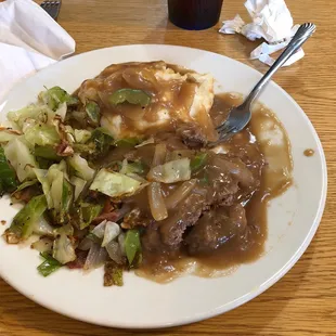 Salisbury steak with mashed potatoes and fried cabbage.