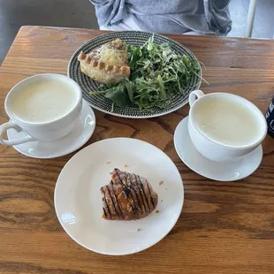 Quiche, matcha lattes in a mug, chocolate croissant.