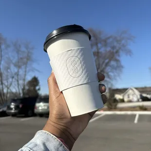 a hand holding a cup of coffee
