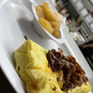an omelet and a bowl of fruit