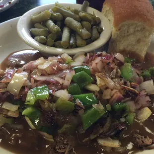 Smothered beef over rice and sautéed onions peppers