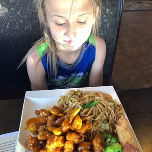 Orange chicken and a happy girl'