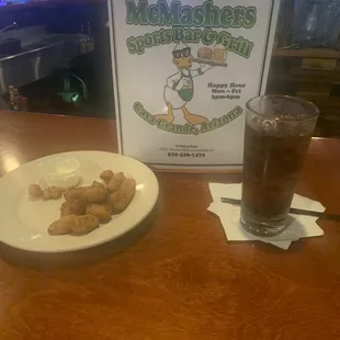 a plate of chicken nuggies and a drink