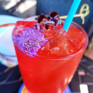 a red drink with purple flowers