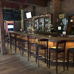 a bar with chairs and a television