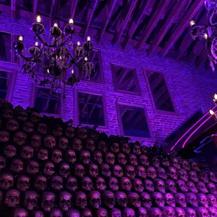 a wall of skulls and a chandelier