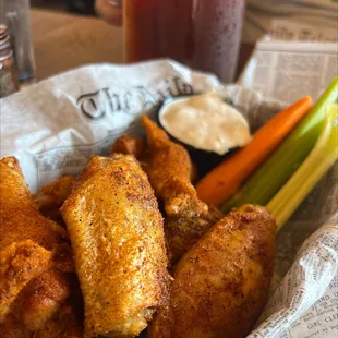 a basket of chicken wings and carrots