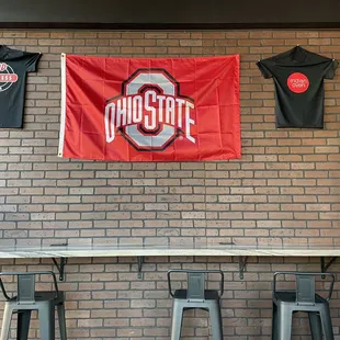 a ohio state flag hanging on a brick wall