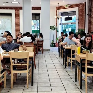 a large group of people eating in a restaurant
