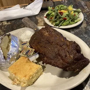 Half slab of ribs with cornbread, baked potato, and veggies
