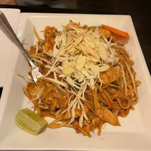 a plate of noodles with meat and vegetables