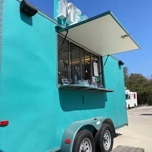 a blue food truck parked in a parking lot