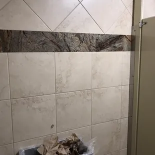 ows a trash can in a bathroom
