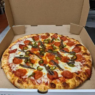 Large pepperoni, jalapeno, anchovy pizza fresh out of the oven