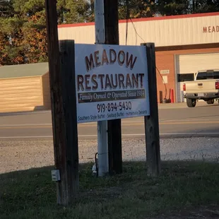 a sign for meadow village restaurant