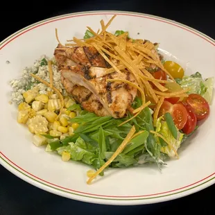 Black &amp; Blue Salad with bleu cheese, avocado, grilled corn, scallions, and bacon, topped with blackened chicken and crispy tortilla strips