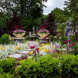 a garden with flowers and statues